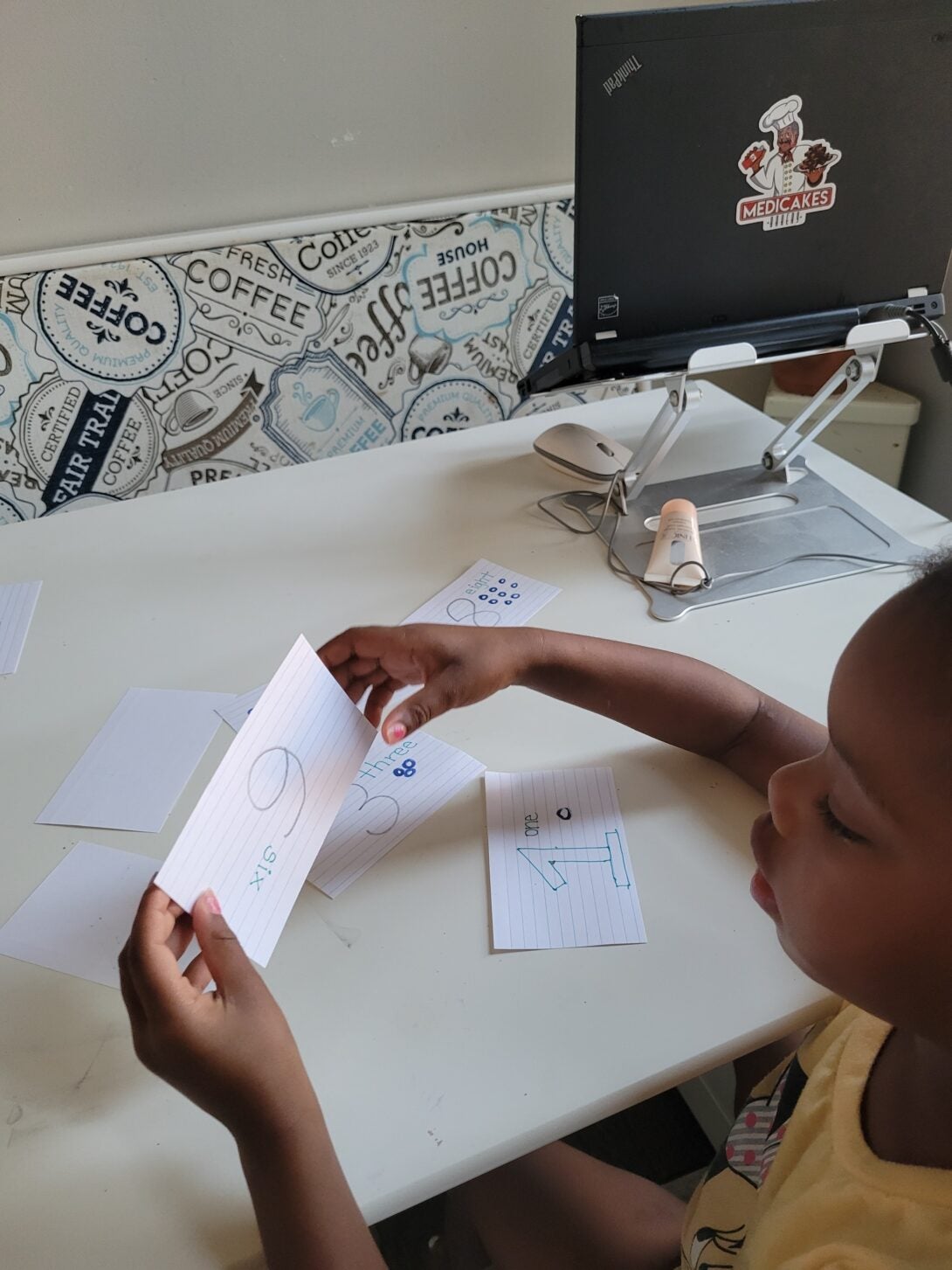 A young boy looks onto his notecards as his mom takes a picture of him.