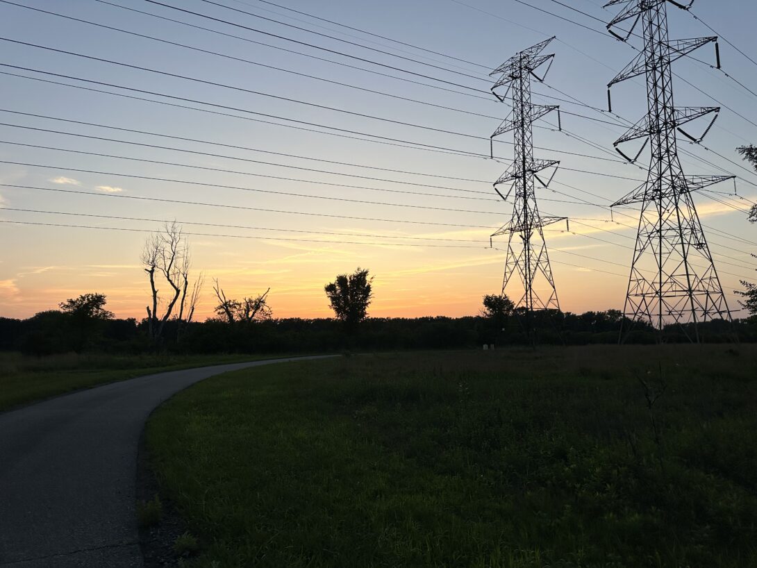 A sunset overlapped by towering electrical lines